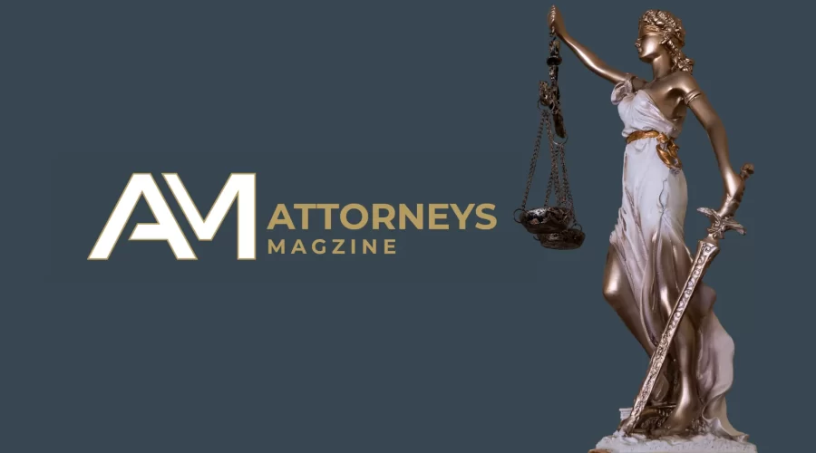 A bronze and white Lady Justice statue holding scales and a sword next to the Attorneys Magazine logo on a dark blue background.